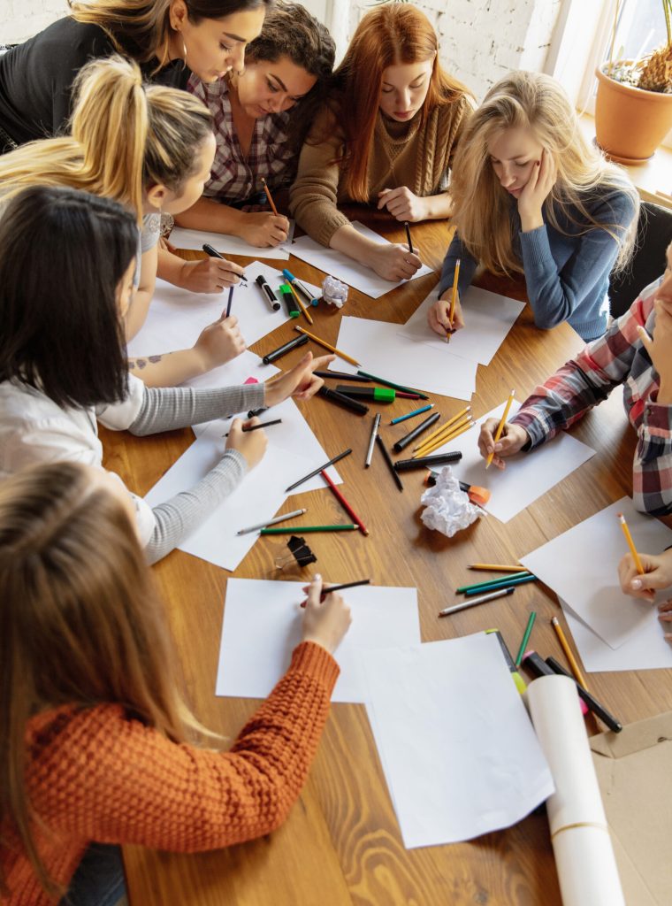 Top view of women preparing poster about women's rights and equality at the office. Caucasian businesswomen or office workers have meeting about problem in workplace, male pressure and harassment.